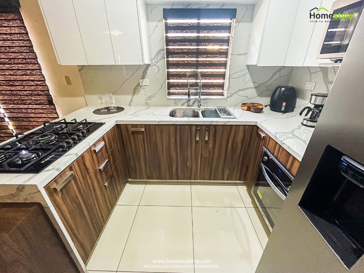 Cocina en forma de L con barra-comedor y cascada. Diseñada en melamina Nogal Terracota para gabinetería inferior y MDF Alto Brillo Blanco para gabinetería superior. Cubierta y Backsplash de Cuarzo Corian Calacatta Natura.