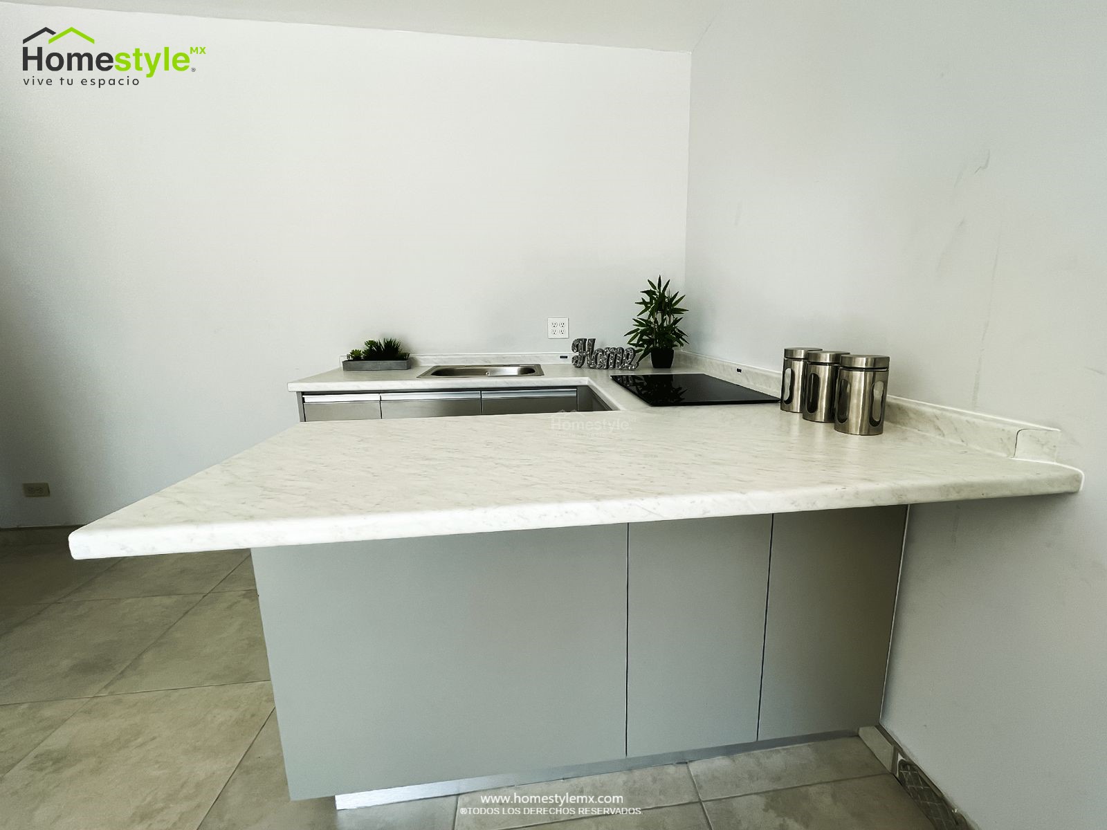 Cocina en forma de J con barra-comedor, diseñada en Melamina Gris Humo para toda la gabinetería. Cubierta de formaica Kober White Carrara