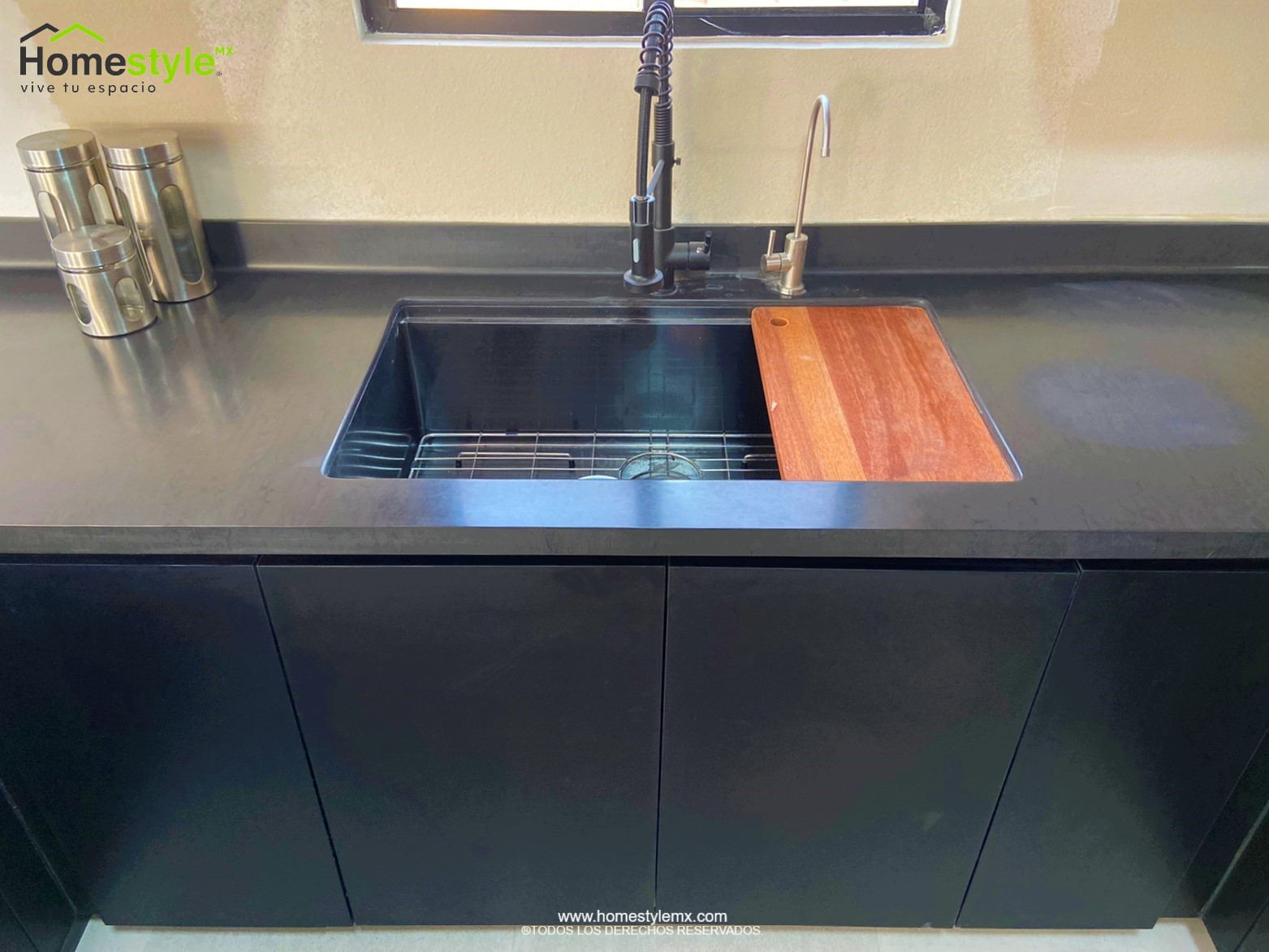 Cocina en forma de J con barra-comedor con estructura, diseñada en Melamina Bestboard Negra para gabinetería inferior y gabinetes sobre walles y Melamina Vesto Cerezo Sierra para gabinetería superior. Puerta de alacena en Melamina Bestboard Negro Mate. Cubierta de cocina de superficie solida Saharan Night y de comedor en Formaica Wild Cherry.