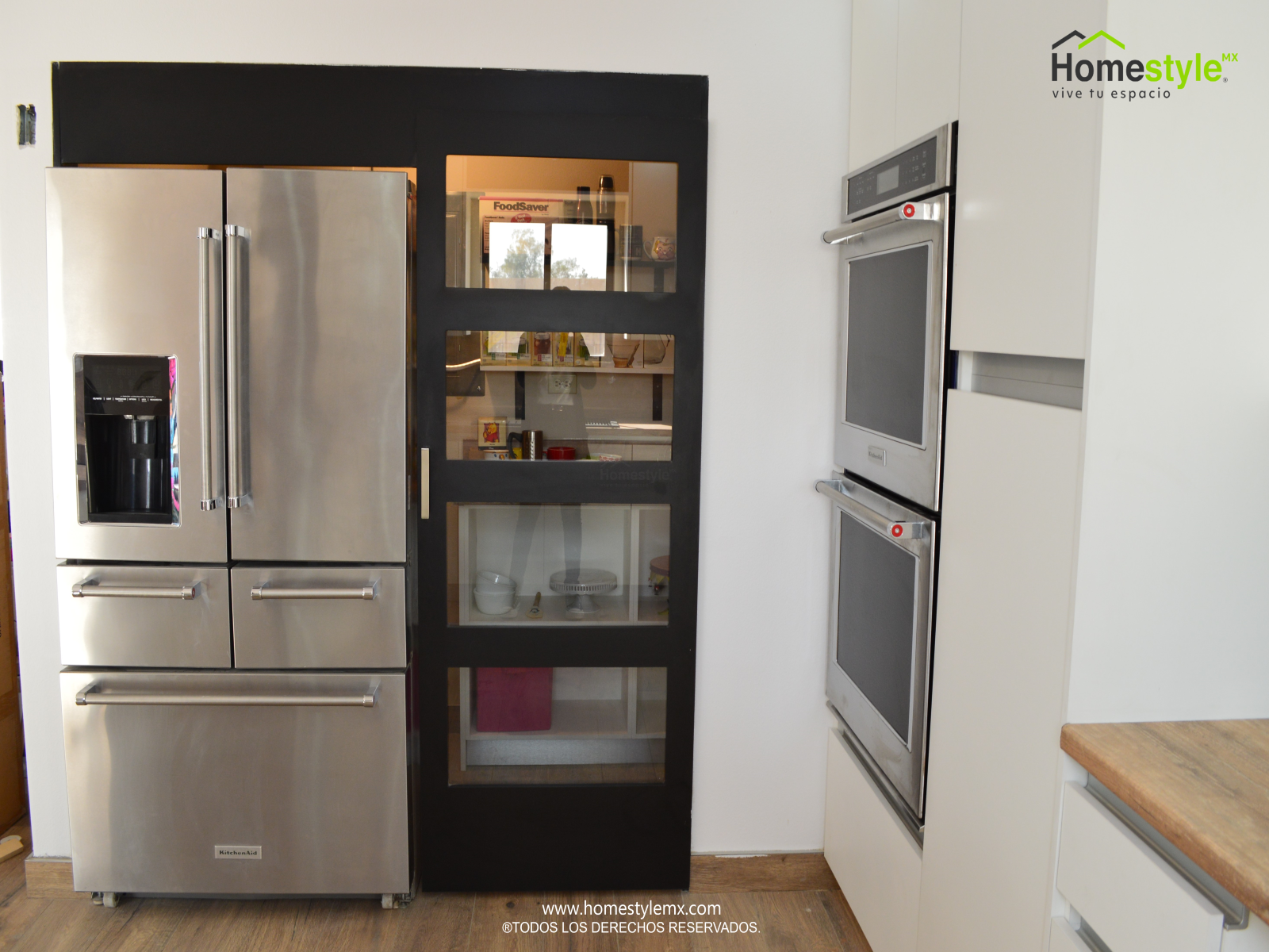 Cocina en forma de J con barra-comedor, diseñada en Melamina Bestboard Blanca para toda la gabinetería. Puerta de alacena en Melamina Bestboard Negro Mate y Cubierta con Backsplash de Formaica Rovere Slavonia.