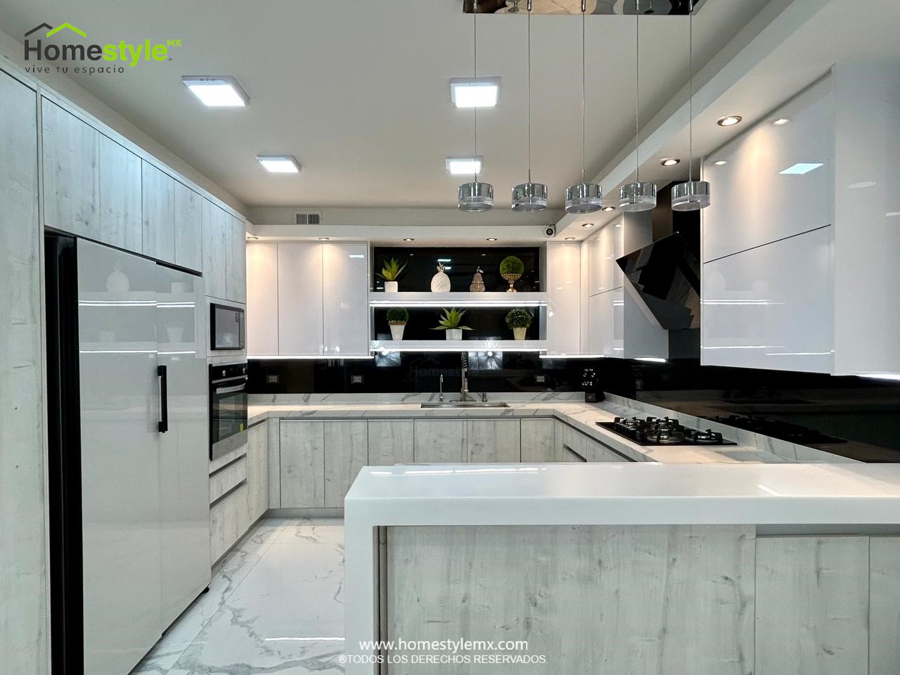 Hermosa cocina en forma de J con barra comedor para 3 personas. Diseñada en Melamina Vesto Alaska para gabinetería inferior, MDF Alto Brillo Blanco para gabinetes superiores y backsplash en MDF Alto Brillo Negro, sistema de iluminación integrada tanto en gabinetes como en cubierta y zoclos. Con una cubierta de Cuarzo Calcutta Marble para la cocina y Superficie Solida Wilsonart Super White para la barra. ✨