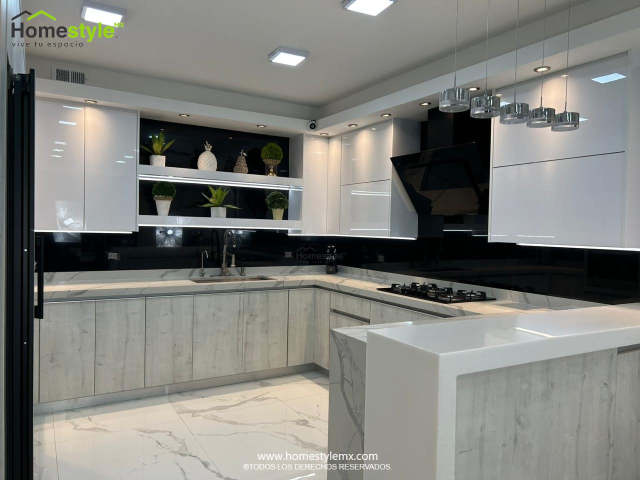 Hermosa cocina en forma de J con barra comedor para 3 personas. Diseñada en Melamina Vesto Alaska para gabinetería inferior, MDF Alto Brillo Blanco para gabinetes superiores y backsplash en MDF Alto Brillo Negro, sistema de iluminación integrada tanto en gabinetes como en cubierta y zoclos. Con una cubierta de Cuarzo Calcutta Marble para la cocina y Superficie Solida Wilsonart Super White para la barra. ✨