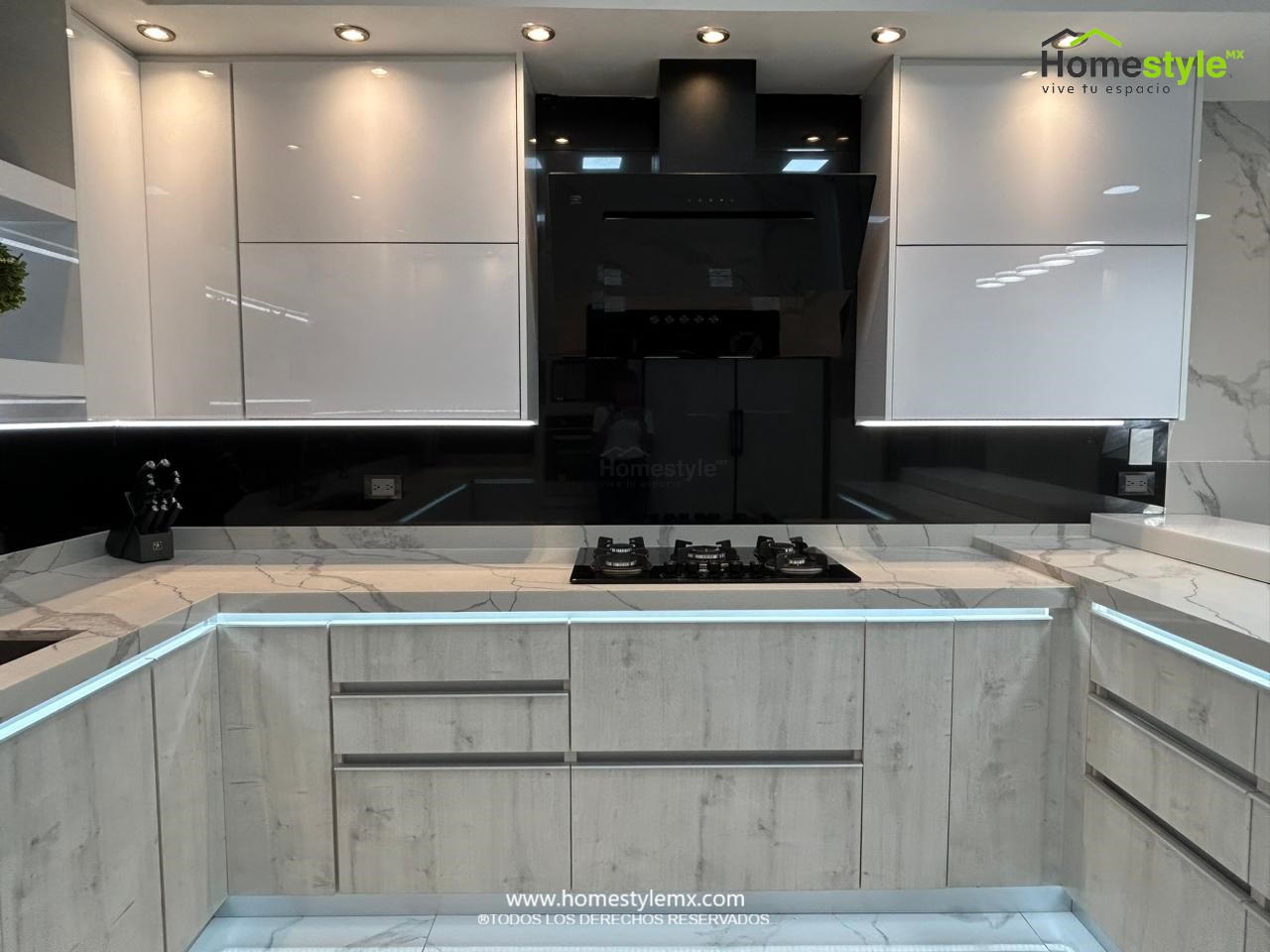 Hermosa cocina en forma de J con barra comedor para 3 personas. Diseñada en Melamina Vesto Alaska para gabinetería inferior, MDF Alto Brillo Blanco para gabinetes superiores y backsplash en MDF Alto Brillo Negro, sistema de iluminación integrada tanto en gabinetes como en cubierta y zoclos. Con una cubierta de Cuarzo Calcutta Marble para la cocina y Superficie Solida Wilsonart Super White para la barra. ✨