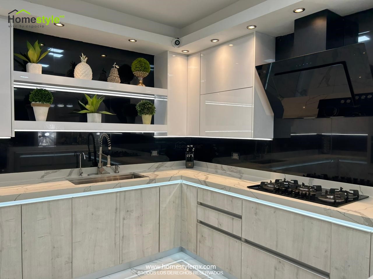 Hermosa cocina en forma de J con barra comedor para 3 personas. Diseñada en Melamina Vesto Alaska para gabinetería inferior, MDF Alto Brillo Blanco para gabinetes superiores y backsplash en MDF Alto Brillo Negro, sistema de iluminación integrada tanto en gabinetes como en cubierta y zoclos. Con una cubierta de Cuarzo Calcutta Marble para la cocina y Superficie Solida Wilsonart Super White para la barra. ✨