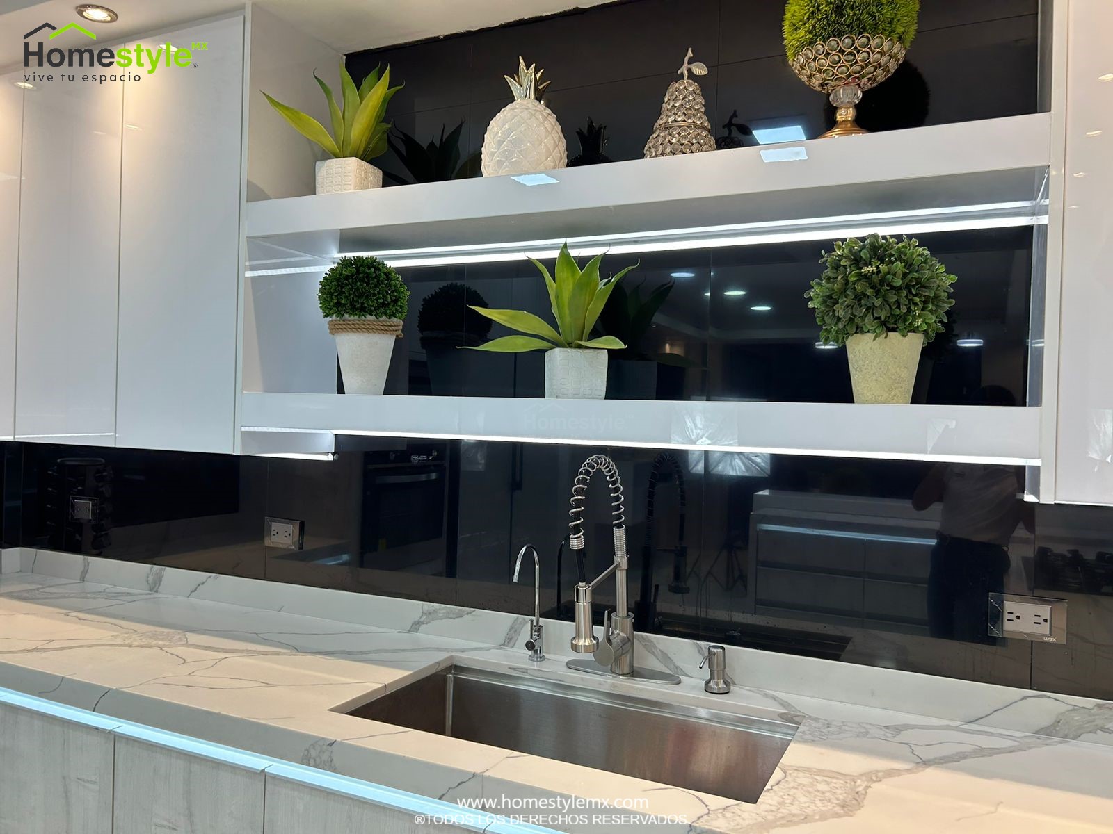 Hermosa cocina en forma de J con barra comedor para 3 personas. Diseñada en Melamina Vesto Alaska para gabinetería inferior, MDF Alto Brillo Blanco para gabinetes superiores y backsplash en MDF Alto Brillo Negro, sistema de iluminación integrada tanto en gabinetes como en cubierta y zoclos. Con una cubierta de Cuarzo Calcutta Marble para la cocina y Superficie Solida Wilsonart Super White para la barra. ✨