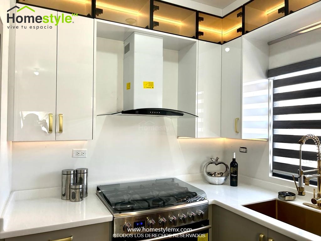 Cocina en forma de J con barra comedor. Diseñada en Melamina Gris para gabinetes inferiores y MDF Alto Brillo Luxe Blanco para gabinetería superior, Vidrio en puertas superiores y detalles en lambrin cedro bajo la barra. Con una cubierta de Superficie Solida Wilsonart Artic Dune.