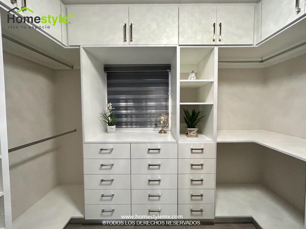 Hermoso walking closet en forma de J. Diseñado en Melamina Blanca en su totalidad, con una gran variedad de cajonnes, amplios espacios de almacenamiento con maleteros y tubos para colgar.