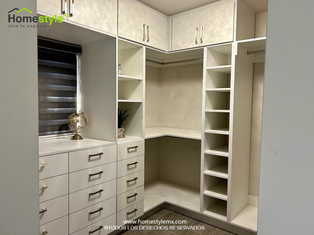 Hermoso walking closet en forma de J. Diseñado en Melamina Blanca en su totalidad, con una gran variedad de cajonnes, amplios espacios de almacenamiento con maleteros y tubos para colgar.