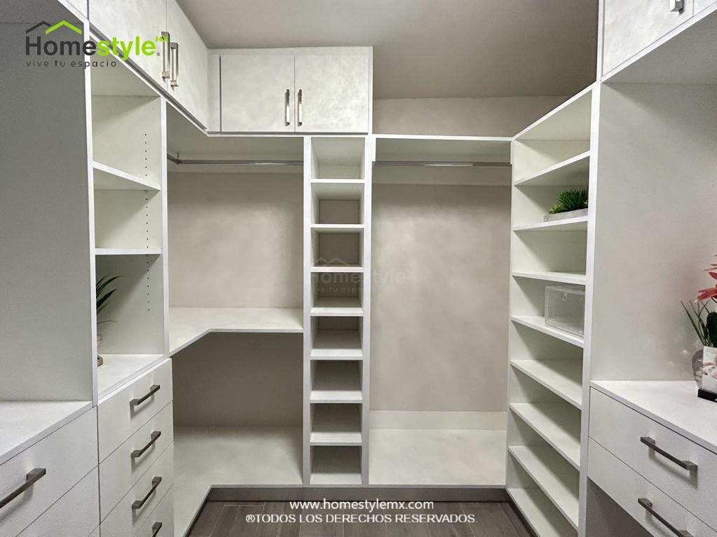 Hermoso walking closet en forma de J. Diseñado en Melamina Blanca en su totalidad, con una gran variedad de cajonnes, amplios espacios de almacenamiento con maleteros y tubos para colgar.