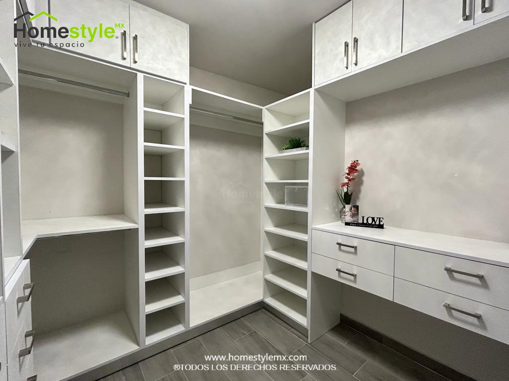 Hermoso walking closet en forma de J. Diseñado en Melamina Blanca en su totalidad, con una gran variedad de cajonnes, amplios espacios de almacenamiento con maleteros y tubos para colgar.