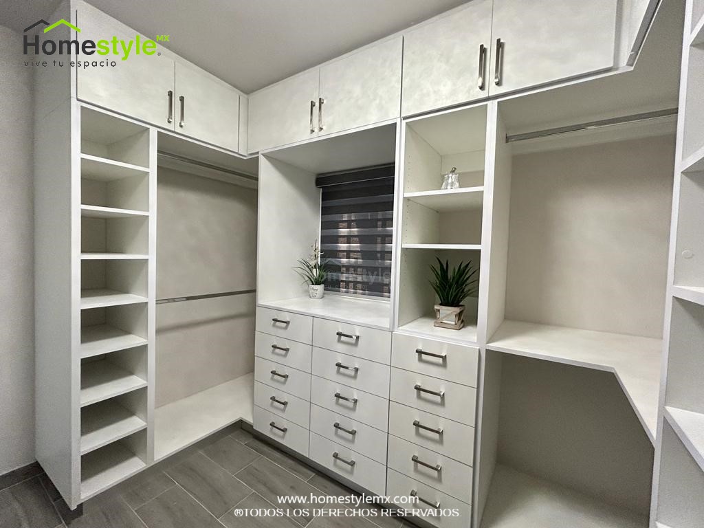 Hermoso walking closet en forma de J. Diseñado en Melamina Blanca en su totalidad, con una gran variedad de cajonnes, amplios espacios de almacenamiento con maleteros y tubos para colgar.