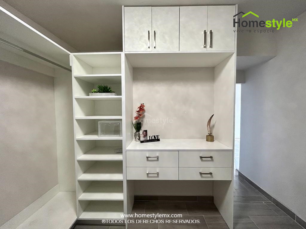 Hermoso walking closet en forma de J. Diseñado en Melamina Blanca en su totalidad, con una gran variedad de cajonnes, amplios espacios de almacenamiento con maleteros y tubos para colgar.