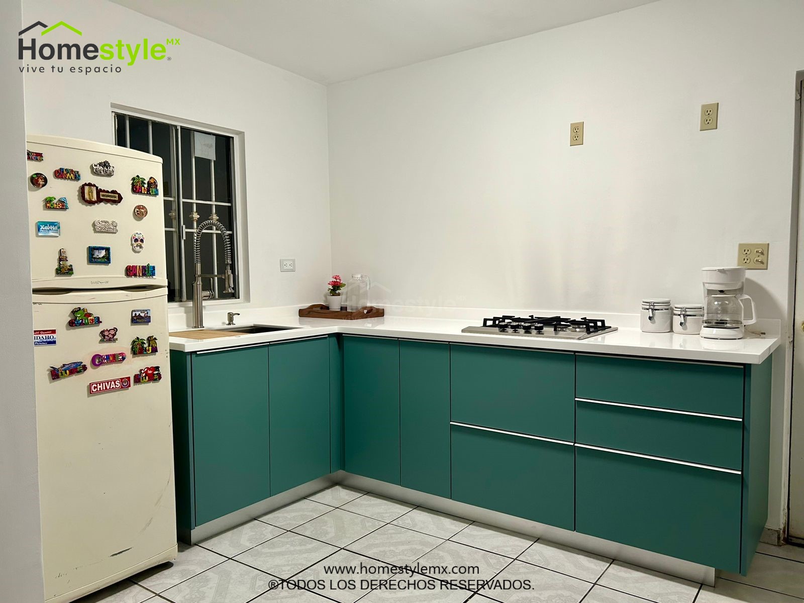 Cocina en forma de L. Diseñado en MDF Super Matte Green. Con una cubierta de superficie solida Frosty White.