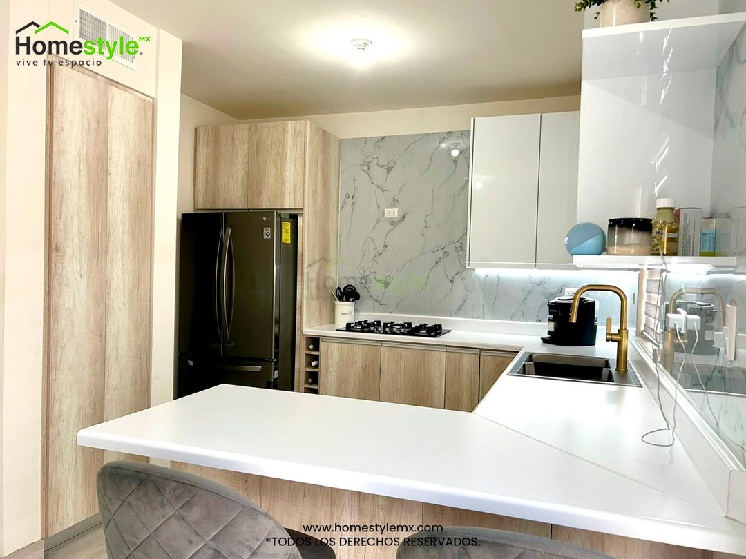 Cocina en forma de L con barra comedor y área de alacena. Diseñada en Melamina Toscana para gabinetes inferiores y MDF Alto Brillo Blanco para gabinetería superior. Con una cubierta de Formaica Blanca. Backsplash de Laminado de PVC Marmoleado Blanco.