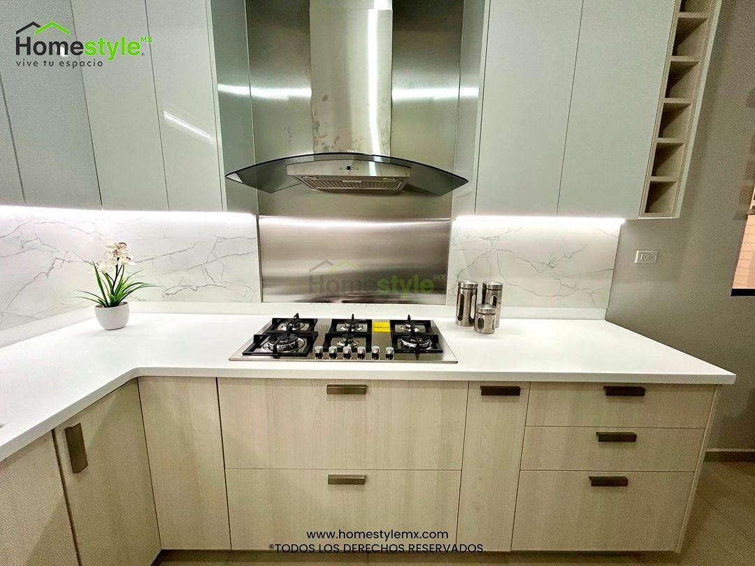 Cocina en forma de U. Diseñada en Melamina Teka Ártico y MDF Alto Brillo Blanco en gabinetes, con una cubierta de Superficie Solida Frosty White. Backsplash en Melamina Marmara. Instalación y venta de iluminación incluida.