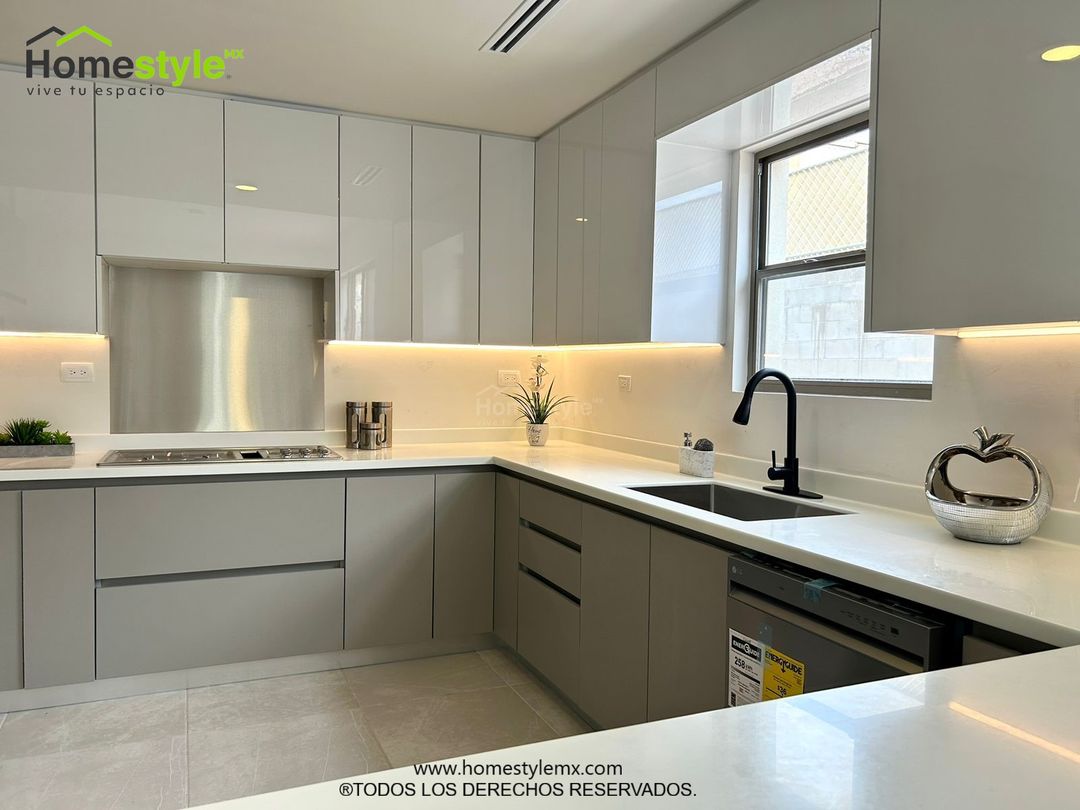 Cocina en forma de J con barra comedor para 3 personas. Diseñada en Melamina Gris para gabinetes inferiores y MDF Alto Brillo Luxe Blanco para gabinetería superior. Con una cubierta de Superficie Solida Frosty White.