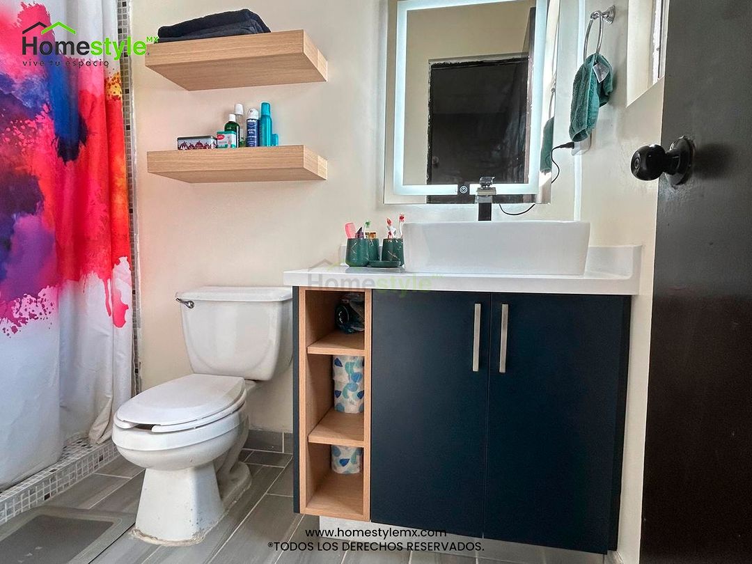 Mueble de Baño realizado en Melamina Zafiro y Melamina Roble Americano para las repisas con una cubierta de Superficie Sólida Frosty White.